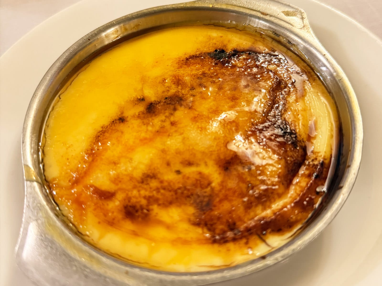Crema catalana de Can Culleretes servida en cazuela metálica, con la capa de azúcar quemada